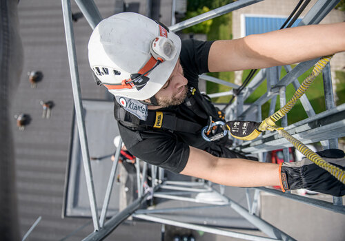 A CERTEX Lifting employee climbs scaffolding while wearing the Aspire sustainable safety harness. 