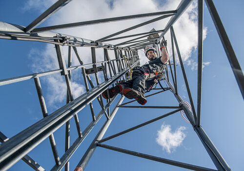 A CERTEX Lifting employee climbing scaffolding while wearing the Aspire sustainable safety harness.