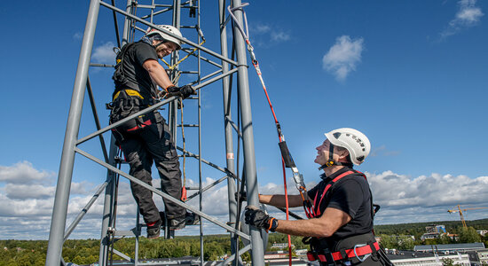 Two CERTEX Lifting employees stand on scaffolding while wearing the Aspire sustainable harness.